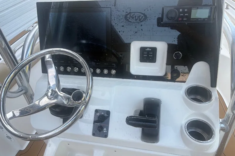 Slide: The Image of Steering console of 2020 Key West 203 FS boat with controls and cup holders. - 52