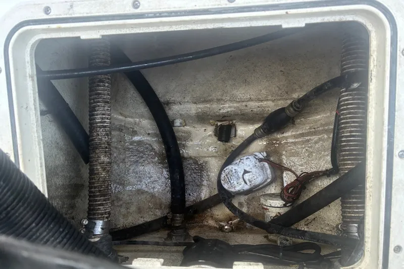 Slide: The Image of Bilge area of a 2020 Key West 203 FS boat with hoses and wiring visible. - 29