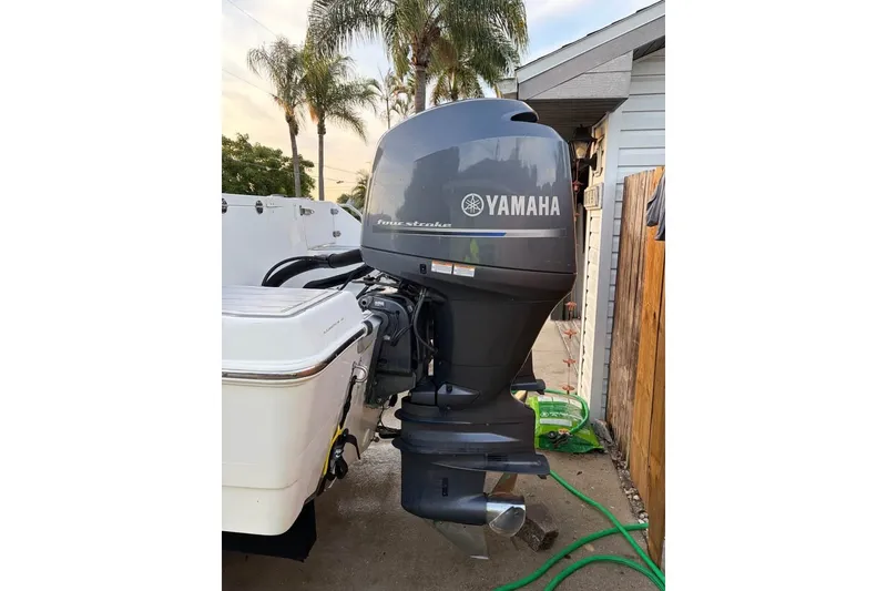 Slide: The Image of 2015 NauticStar 2500XS Offshore with Yamaha outboard motor, parked near palm trees. - 2