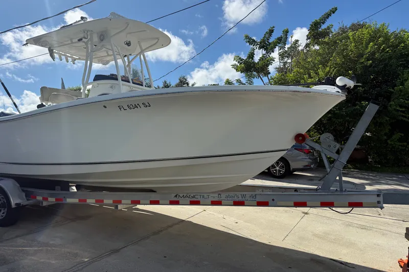 The Image of 2015 NauticStar 2500XS Offshore boat on trailer under clear blue sky. - 0