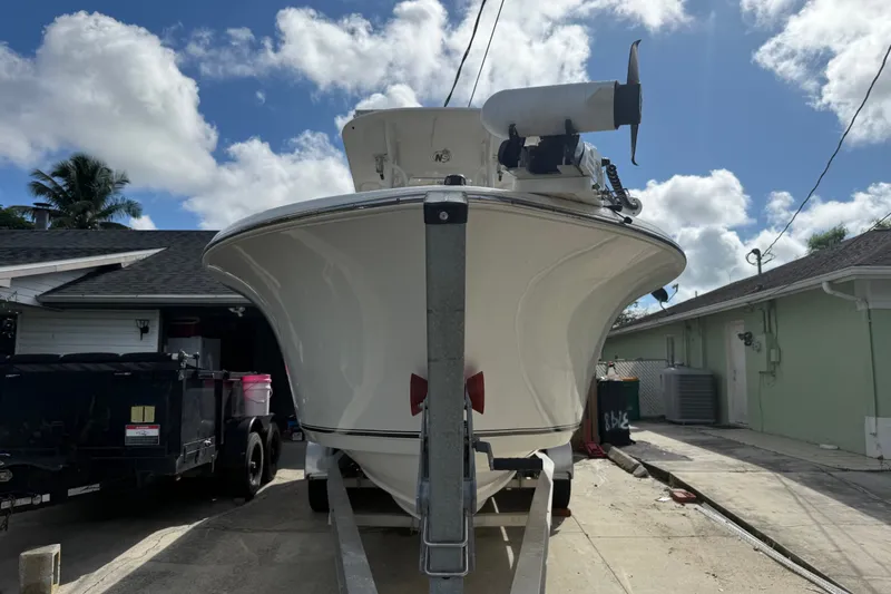 Slide: The Image of 2015 NauticStar 2500XS Offshore boat on trailer, parked in driveway under blue sky. - 14
