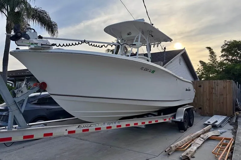 Slide: The Image of 2015 NauticStar 2500XS Offshore boat on trailer, parked in driveway. - 1