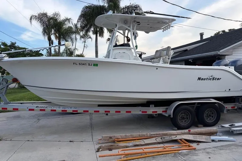 The Image of 2015 NauticStar 2500XS Offshore boat on trailer, parked in driveway. - 0