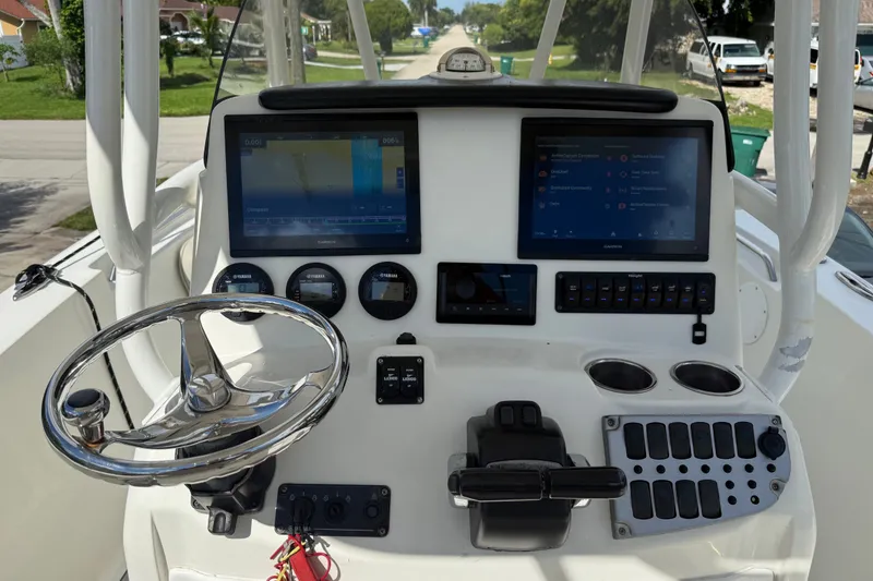 Slide: The Image of 2015 NauticStar 2500XS Offshore boat dashboard with dual Garmin displays and steering wheel. - 26