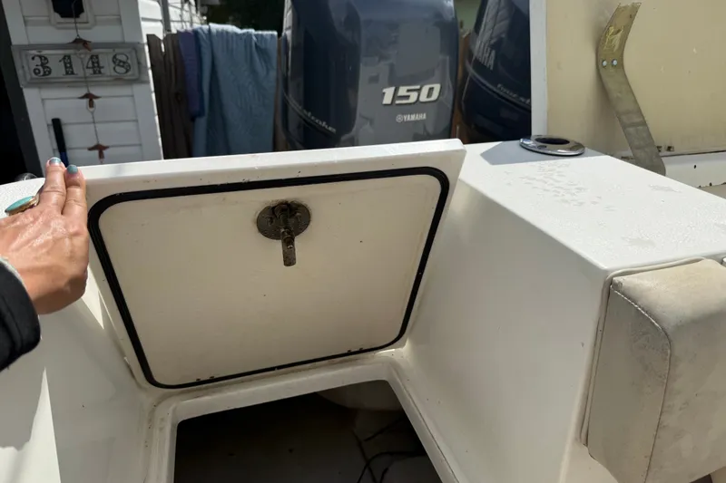 Slide: The Image of 2015 NauticStar 2500XS Offshore boat with Yamaha 150 engine, showing storage compartment. - 49