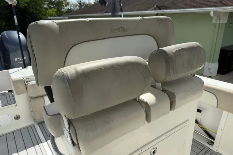 Slide: The Image of 2015 NauticStar 2500XS Offshore boat seats, featuring cushioned armrests and backrests. - 25