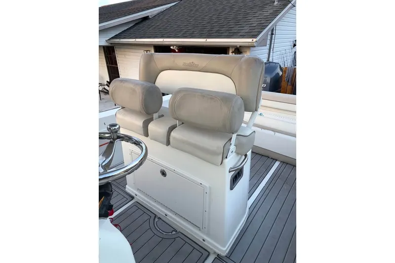 Slide: The Image of 2015 NauticStar 2500XS Offshore boat seating and helm, featuring cushioned seats and steering wheel. - 9