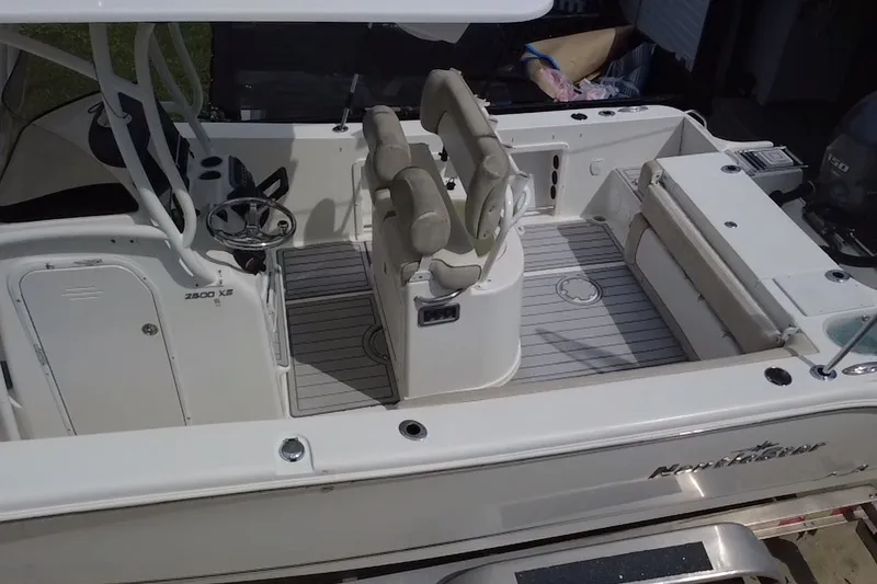 Slide: The Image of 2015 NauticStar 2500XS Offshore boat interior with seating and steering wheel. - 21