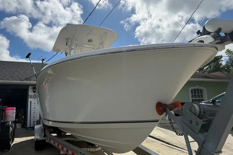 Slide: The Image of 2015 NauticStar 2500XS Offshore boat on trailer under a partly cloudy sky. - 17