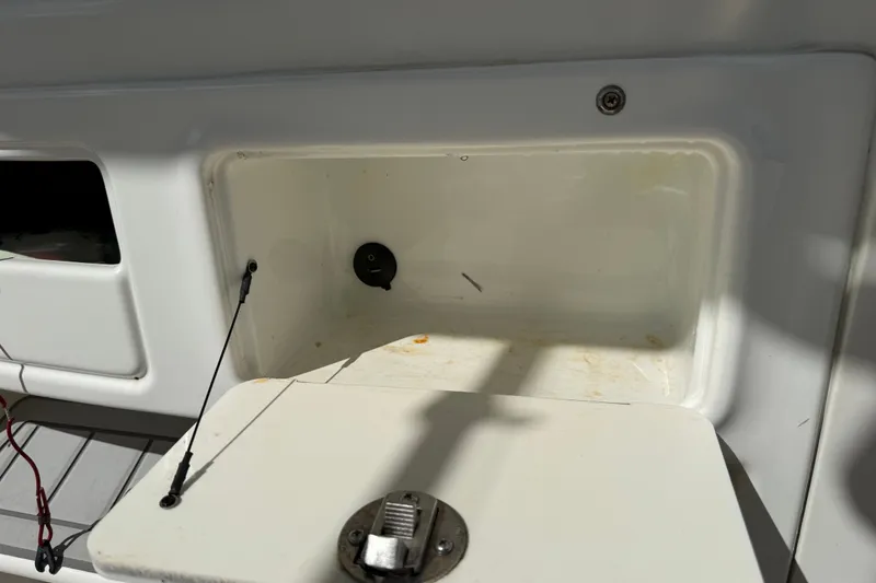 Slide: The Image of Storage compartment on a 2015 NauticStar 2500XS Offshore boat, featuring a latch and wiring. - 32
