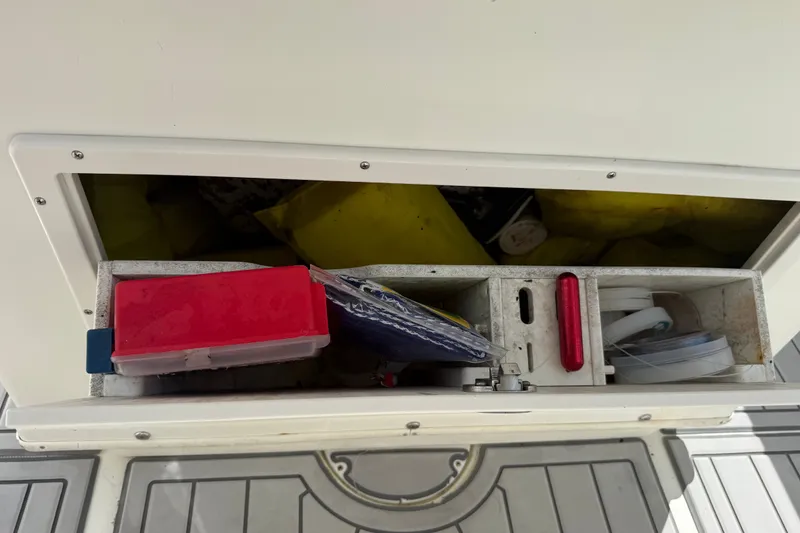 Slide: The Image of Storage compartment on a 2015 NauticStar 2500XS Offshore boat, containing various items. - 33