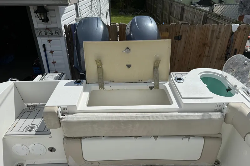 Slide: The Image of 2015 NauticStar 2500XS Offshore boat interior with open storage compartment and dual engines. - 48