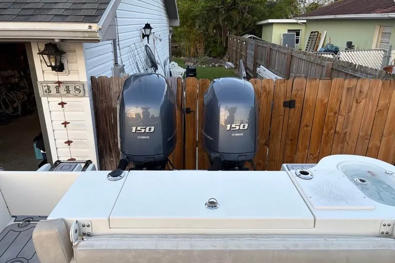 Slide: The Image of 2015 NauticStar 2500XS Offshore boat with dual Yamaha 150 engines in a residential setting. - 10