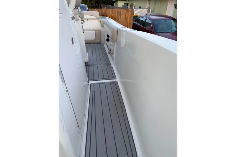 Slide: The Image of 2015 NauticStar 2500XS Offshore boat deck with gray flooring and seating area. - 6