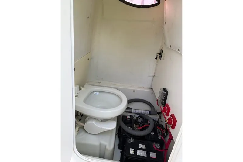 Slide: The Image of Interior of 2015 NauticStar 2500XS Offshore boat showing toilet and battery compartment. - 11