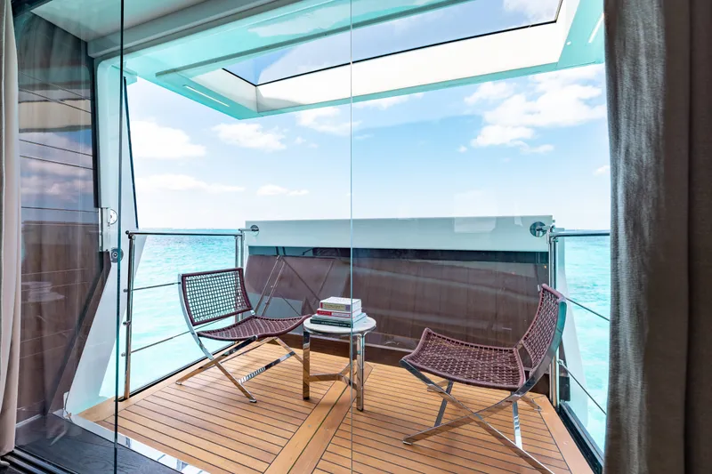 Slide: The Image of Luxurious Benetti Motoryacht balcony with ocean view, featuring modern chairs and a glass railing. - 14