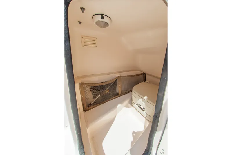 Slide: The Image of 2007 Grady-White Tournament 205 boat interior storage compartment with netting and portable toilet. - 3