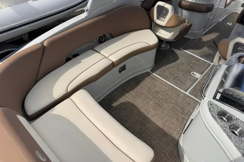 Slide: The Image of 2022 Crownline Eclipse E285 XS boat interior with beige seating and carpeted flooring. - 9