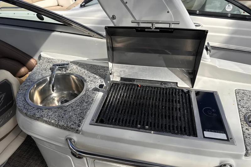 Slide: The Image of 2022 Crownline Eclipse E285 XS boat with built-in grill and sink on deck. - 12