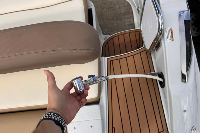 Slide: The Image of Hand holding shower hose on 2022 Crownline Eclipse E285 XS boat deck. - 7