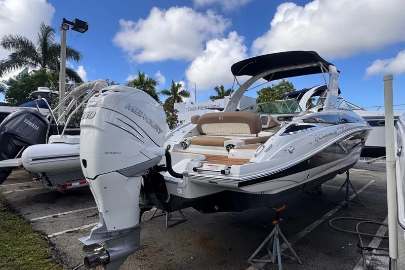 Slide: The Image of 2022 Crownline Eclipse E285 XS boat with Mercury engine, displayed outdoors under blue sky. - 5