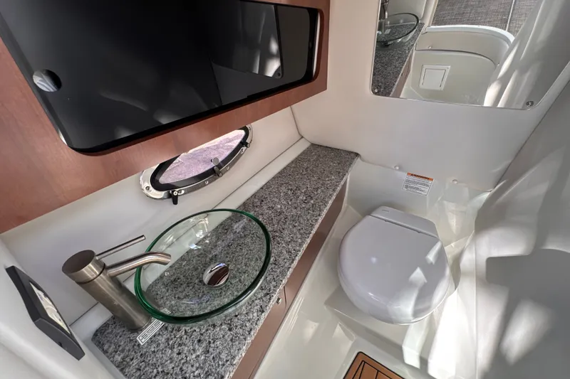 Slide: The Image of 2022 Crownline Eclipse E285 XS boat bathroom with modern sink and toilet. - 14