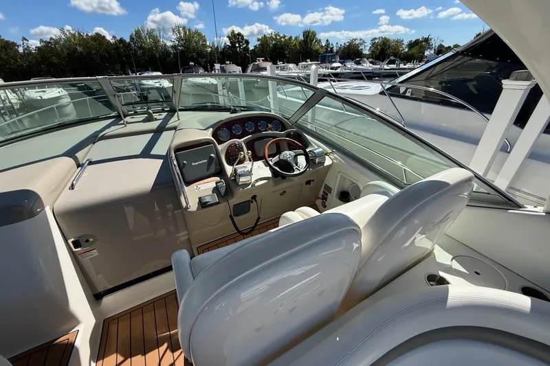 Slide: The Image of 2007 Sea Ray 340 Sundancer cockpit with steering wheel and control panel, docked under blue sky. - 28