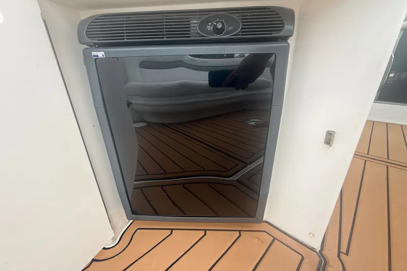 Slide: The Image of 2007 Sea Ray 340 Sundancer boat interior with a sleek black mini fridge. - 24