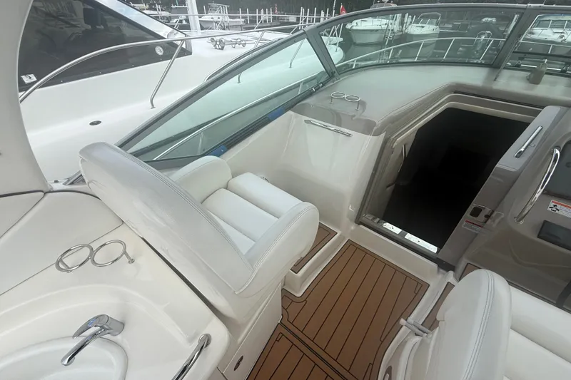 Slide: The Image of 2007 Sea Ray 340 Sundancer cockpit with white seating and wood flooring. - 25