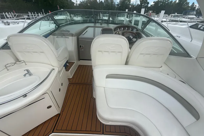 Slide: The Image of 2007 Sea Ray 340 Sundancer cockpit with white seating and wooden flooring. - 22