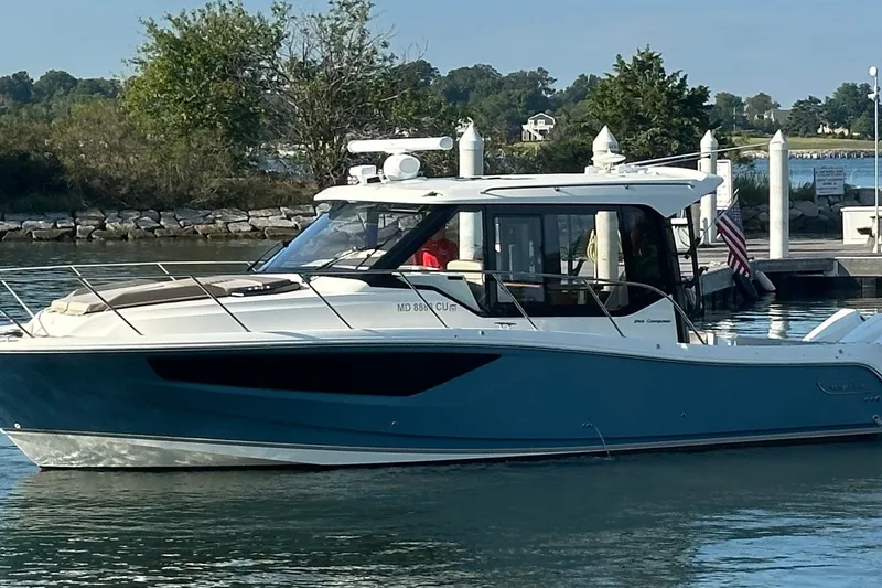 Slide: The Image of 2025 Boston Whaler 365 Conquest boat docked in a serene marina setting. - 4