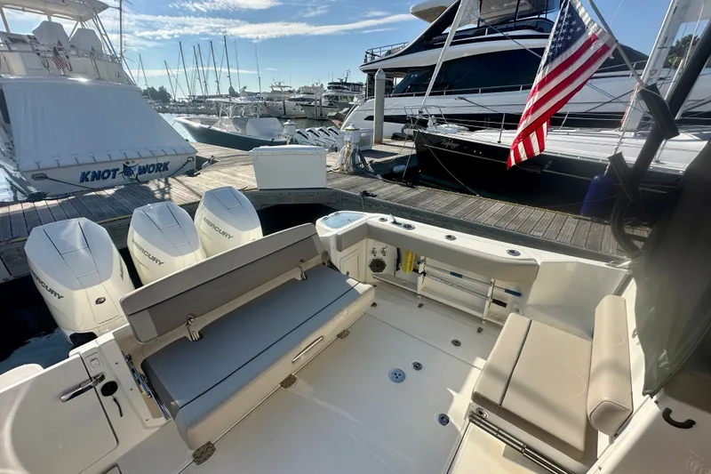 Slide: The Image of 2025 Boston Whaler 365 Conquest boat docked, featuring spacious seating and Mercury engines. - 8