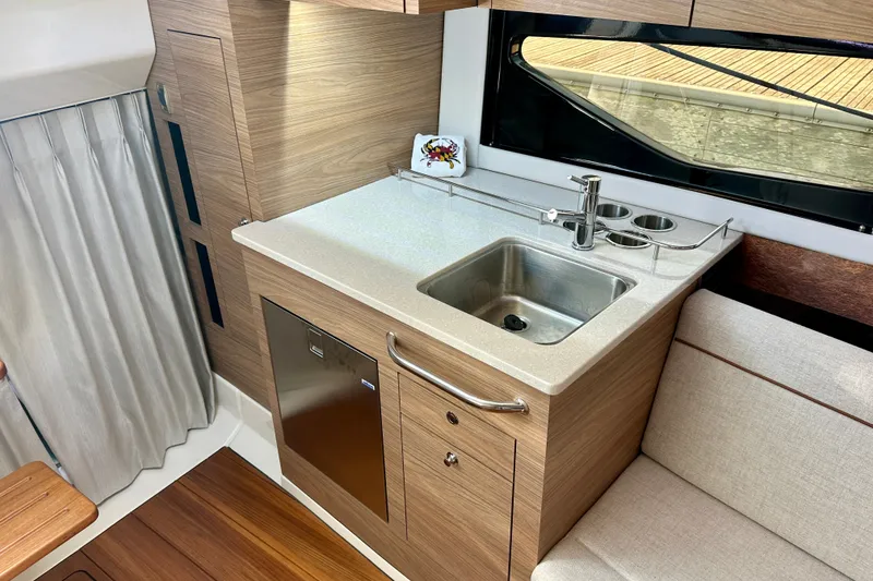 Slide: The Image of 2025 Boston Whaler 365 Conquest interior with modern kitchenette and stainless steel sink. - 15