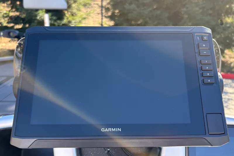 Slide: The Image of Garmin display on 2027 Tracker Savage 215 boat, featuring control buttons and sunlight reflection. - 17
