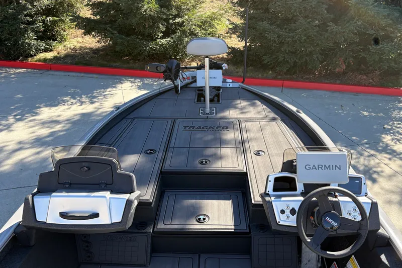 Slide: The Image of 2027 Tracker Savage 215 boat interior with Garmin navigation system, parked outdoors. - 20