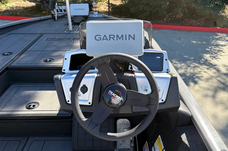 Slide: The Image of 2027 Tracker Savage 215 boat dashboard with Garmin navigation system and steering wheel. - 19