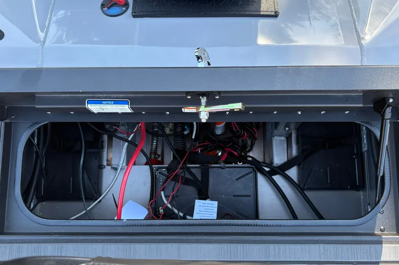 Slide: The Image of Open battery compartment of 2027 Tracker Savage 215 boat, showing wiring and components. - 39
