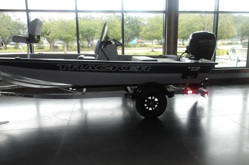 The Image of 2027 Tracker Bass Tracker 175 CC boat displayed indoors with trailer and outboard motor. - 2