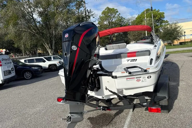 Slide: The Image of 2027 Tahoe T21 boat with outboard motor on a trailer, parked outdoors. - 5
