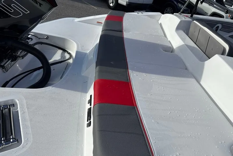 Slide: The Image of 2027 Tahoe T21 boat interior with red and gray seating, wet surface. - 96