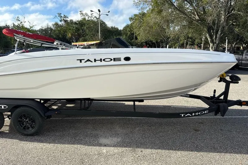 The Image of 2027 Tahoe T21 boat on trailer, parked outdoors under a clear sky. - 0