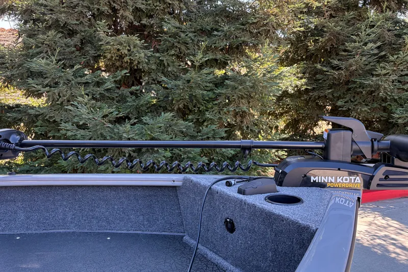 Slide: The Image of 2027 Tracker Pro Guide V-16 SC boat with Minn Kota PowerDrive motor, surrounded by trees. - 16
