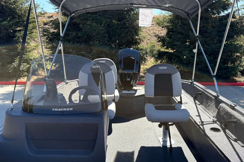 Slide: The Image of 2027 Tracker Pro Guide V-16 SC boat interior with seating and steering console. - 17