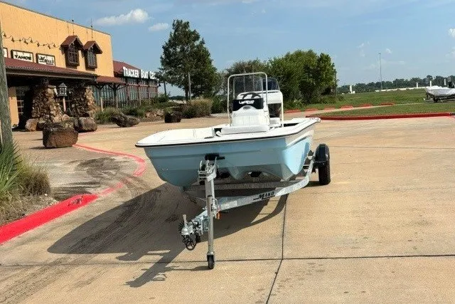 Slide: The Image of 2027 Mako Pro Skiff 17 CC boat on trailer in parking lot near store. - 8