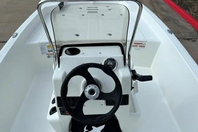 Slide: The Image of 2027 Mako Pro Skiff 17 CC boat console with steering wheel and controls. - 11