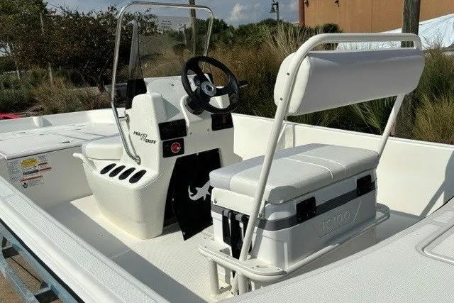 Slide: The Image of 2027 Mako Pro Skiff 17 CC boat interior with steering console and seating. - 9