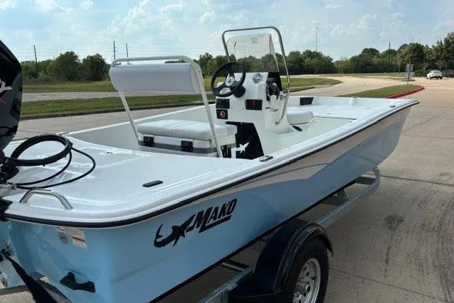 Slide: The Image of 2027 Mako Pro Skiff 17 CC boat on trailer, parked outdoors under a cloudy sky. - 6
