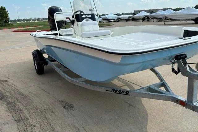 Slide: The Image of 2027 Mako Pro Skiff 17 CC boat on trailer, light blue hull, parked outdoors. - 3