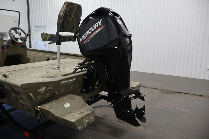 Slide: The Image of 2024 Tracker Grizzly 1860 MVX CC boat with Mercury outboard motor in a garage. - 34