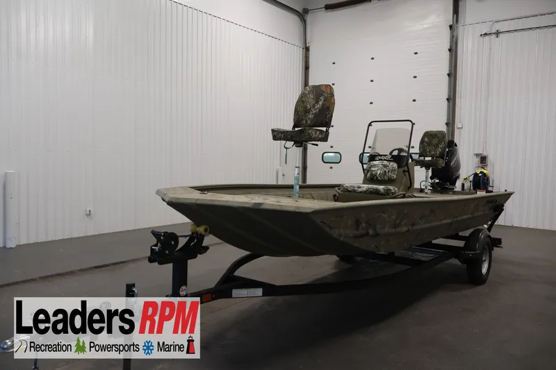The Image of 2024 Tracker Grizzly 1860 MVX CC boat in showroom, camo seats, on trailer. - 1